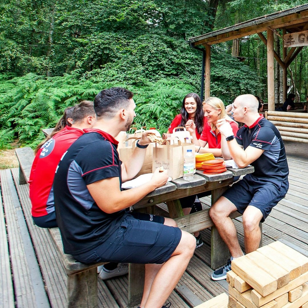 A groups of friends enjoy a picnic in the forest